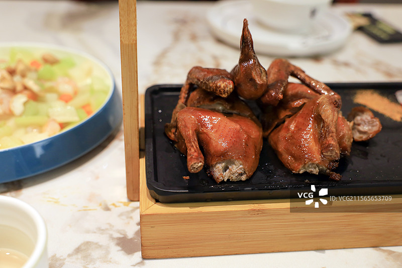 餐桌上的一整只烤乳鸽特写图片素材
