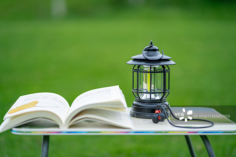 户外小桌子上的书本耳机与户外灯图片素材