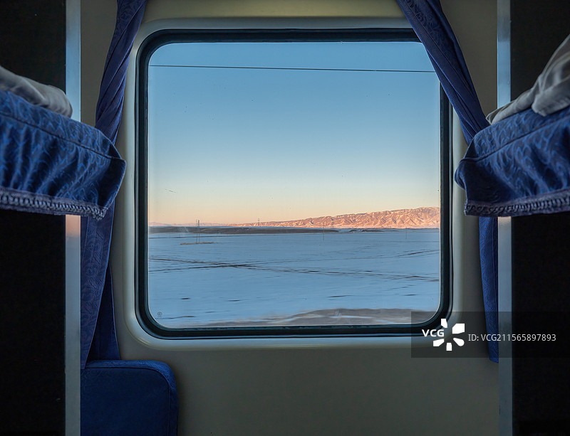 透过窗户看日落时雪原上景色图片素材