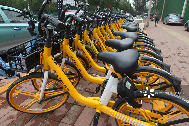 2023年12月31日，重庆江北区共享单车共享自行车整齐停放路边共享单车共享自行车城市出行工具黄车图片素材