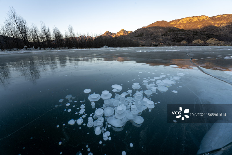 日照金山下的冬季冰面上冰泡图片素材