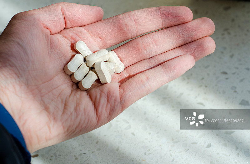 阳光下吃药的手部特写图片素材