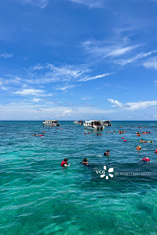 马来西亚沙巴州亚庇环滩岛海域正在参与浮潜运动的人群图片素材