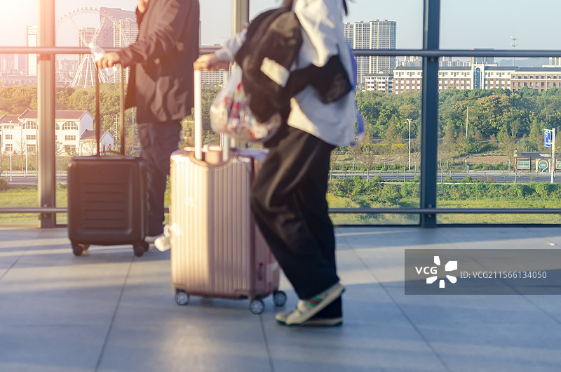 推着行李箱，提着手提包的旅客走在月台上图片素材