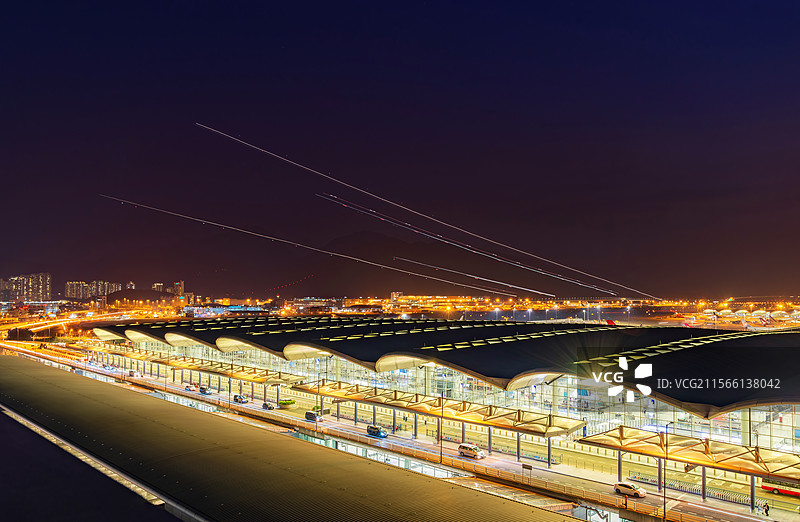 香港国际机场夜景和天空中飞机的灯光轨迹图片素材