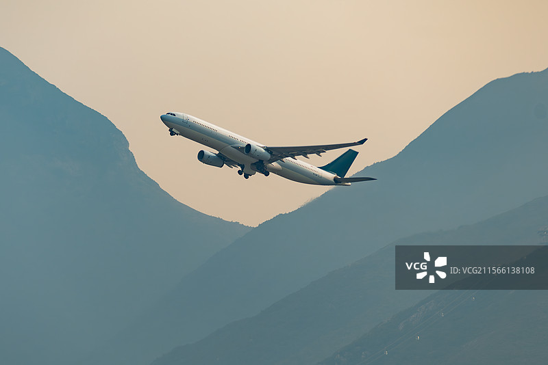 日落时飞机飞过群山图片素材