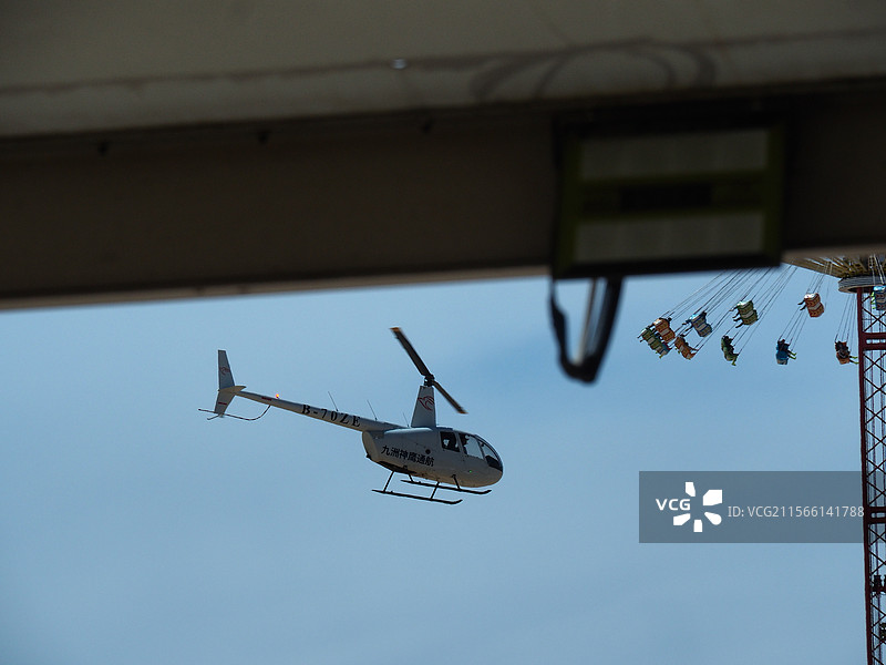 游乐场飞机在晴空中飞行的低角度视图图片素材