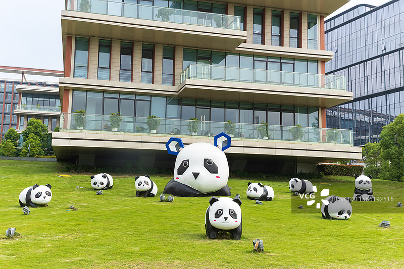 成都天府新区数智谷草地上的大熊猫雕塑和现代建筑景观图片素材