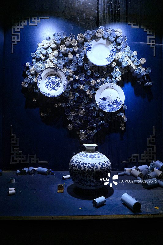 蓝幕为衬青花瓷瓶静立盘碟似绽繁花卷纸错落其间晕染东方古韵尽显雅致风情图片素材