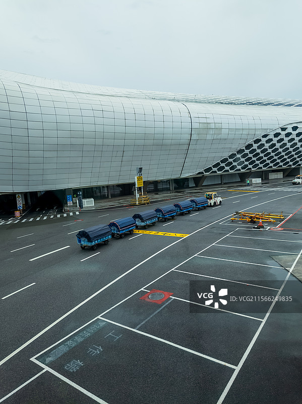机场停机坪场内行李车和现代航站楼图片素材