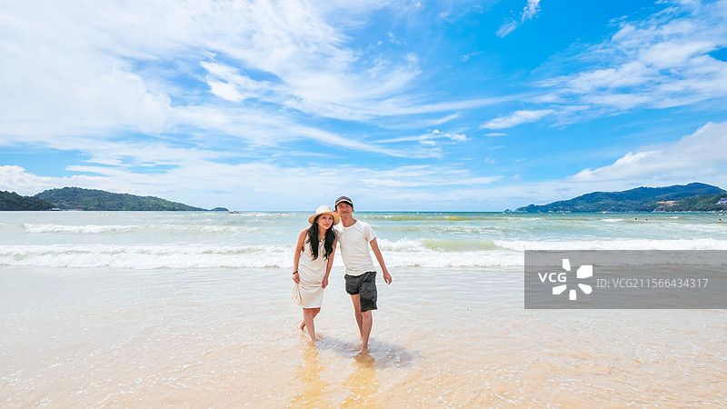 一对亚洲情侣在泰国普吉岛巴东海滩休闲旅游度假图片素材