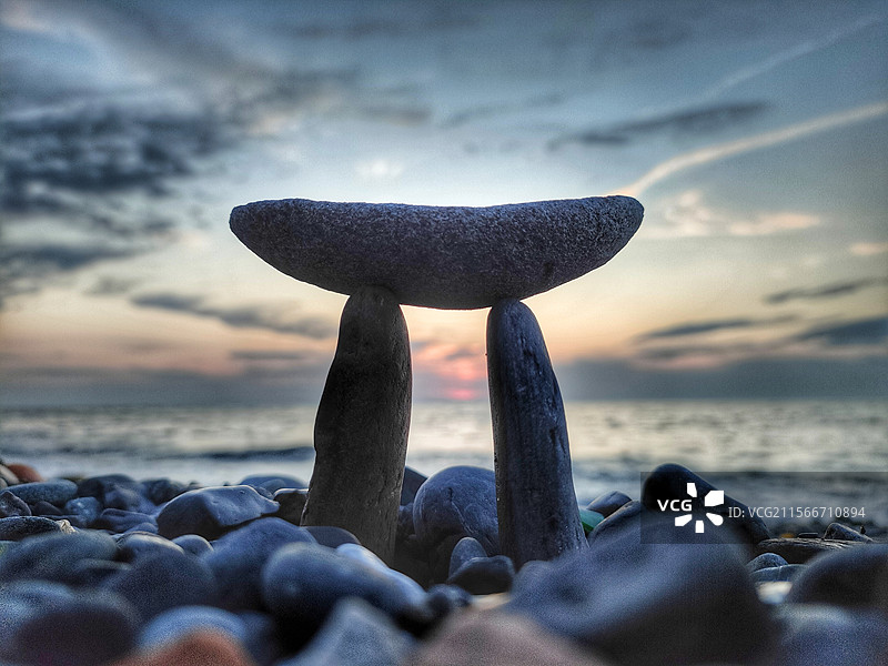 日落时分，土耳其宗古尔达克海滩上的石头特写，背景是天空。图片素材