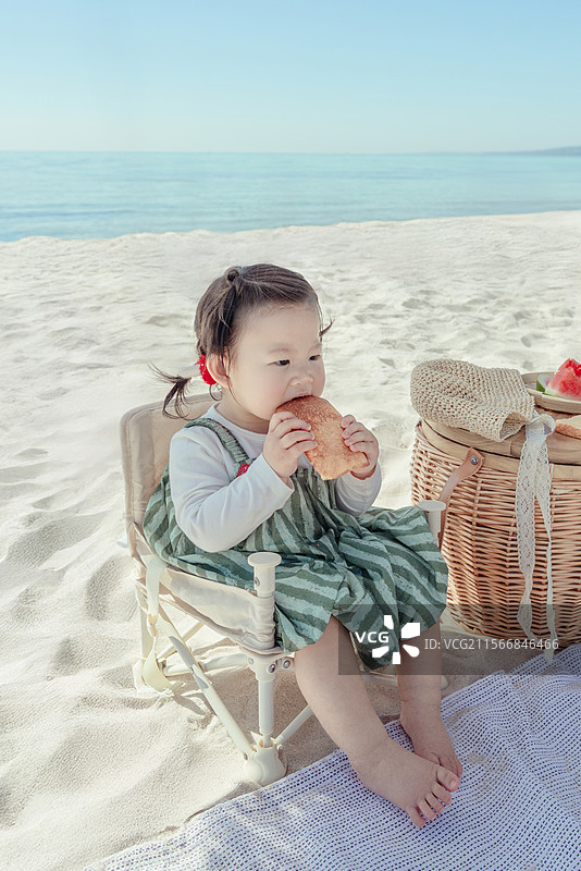 海滩上吃西瓜的一岁小女孩 特写图片素材