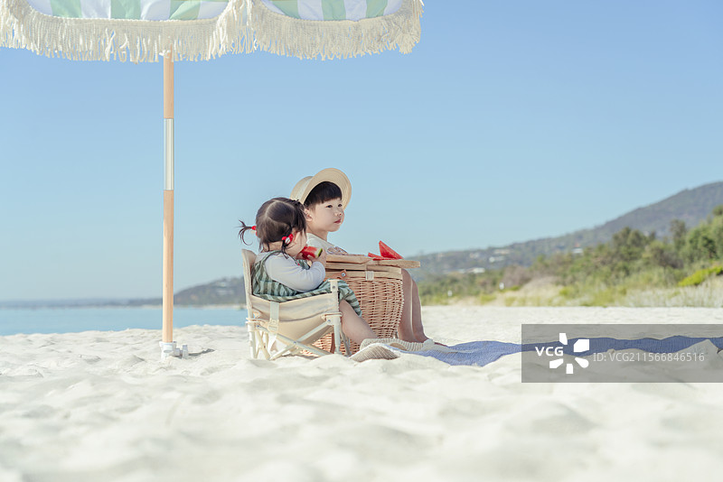 海滩露营享受美食的小男孩与妹妹图片素材