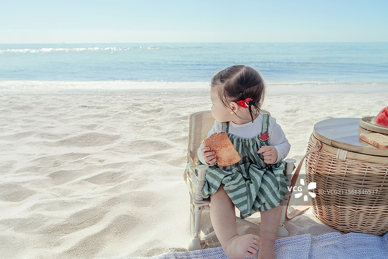 海滩上吃西瓜的一岁小女孩 特写图片素材