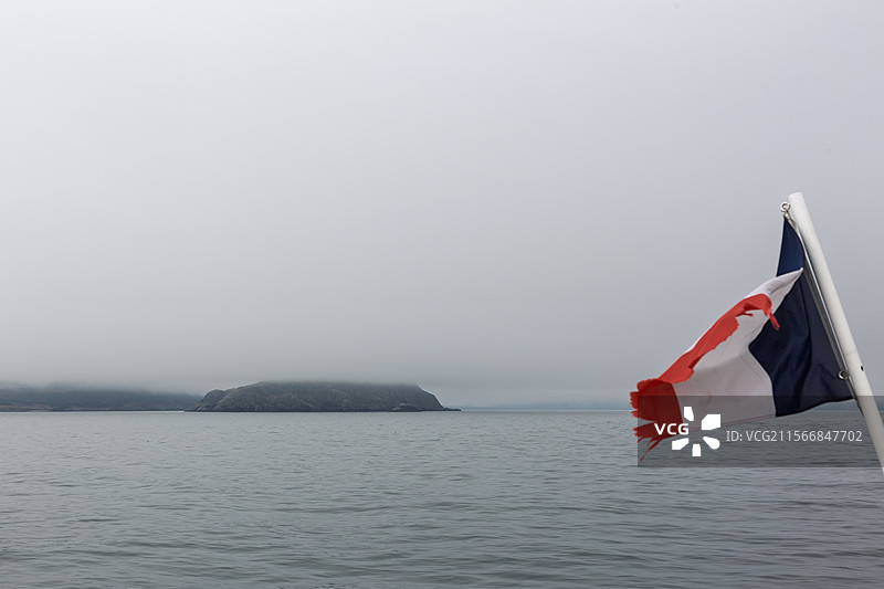 渡轮离开圣皮埃尔与密克隆群岛，空中飘扬的法国国旗特写镜头图片素材