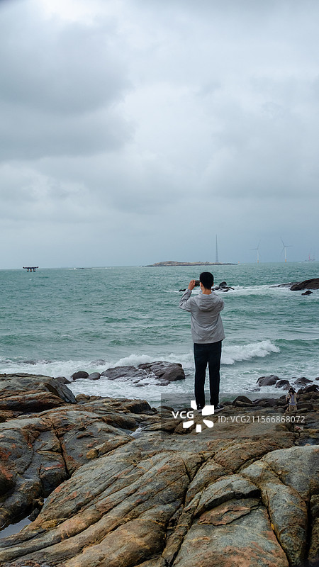 附件平潭岛上，站在大海边拍照图片素材