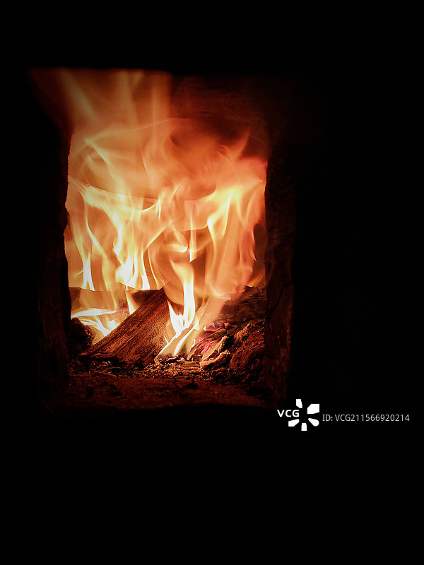 柴火灶：火焰燃烧在柴火灶膛里的特写镜头图片素材