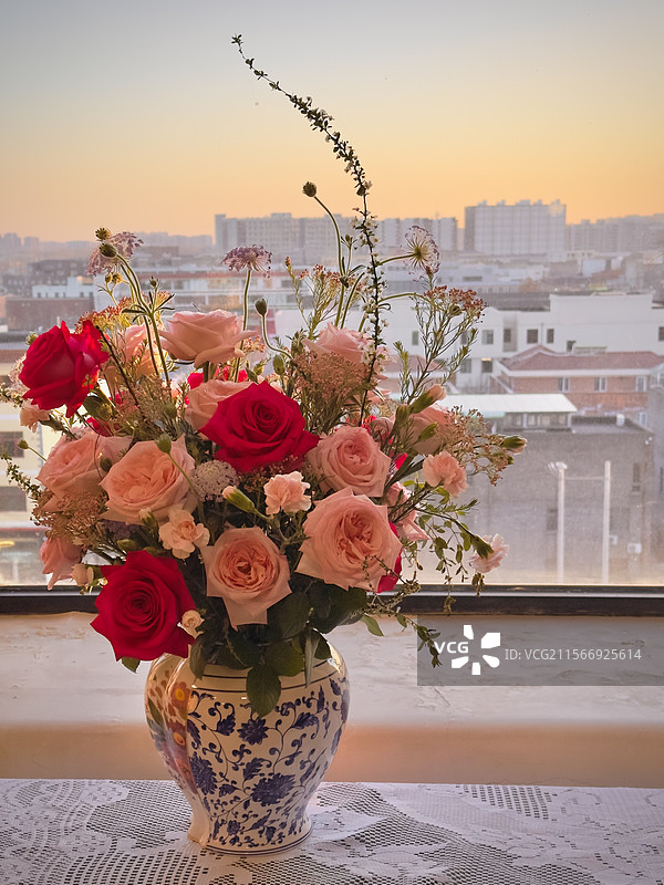 窗边城市背景下的浪漫插花图片素材