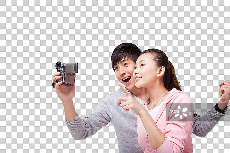 快乐的年轻情侣使用数码摄像机图片素材