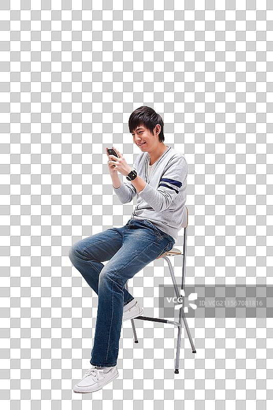 年轻男人做在椅子上使用手机图片素材