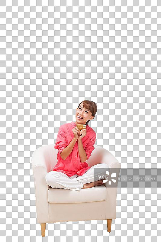 年轻女人坐在沙发上拿着电话卡图片素材