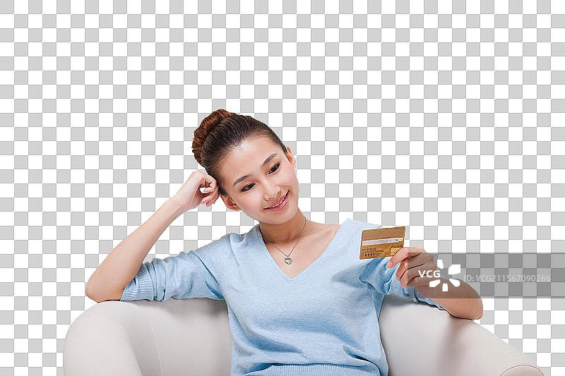 年轻女人坐在沙发上拿着电话卡图片素材