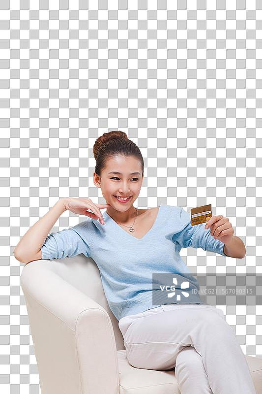 年轻女人坐在沙发上拿着电话卡图片素材