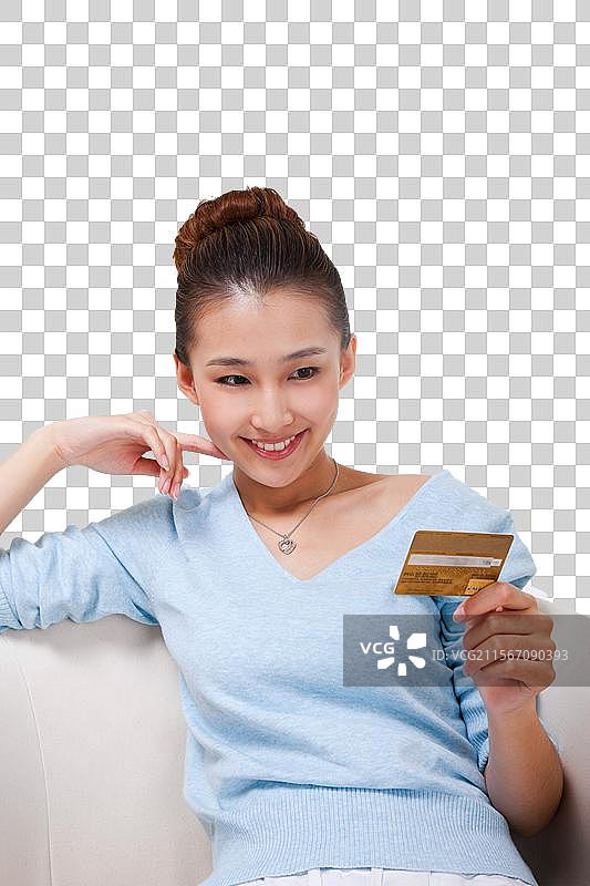 年轻女人坐在沙发上拿着电话卡图片素材