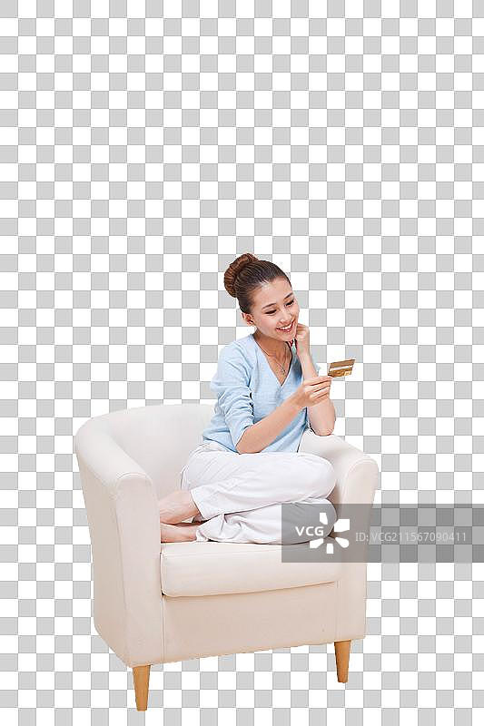年轻女人坐在沙发上拿着电话卡图片素材