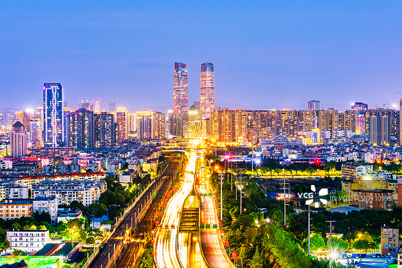 云南昆明地标建筑：万达双塔夜景，前景为二环快速路、成昆铁路图片素材