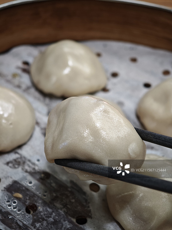 筷子夹蒸笼里的中式汤包特写图片素材