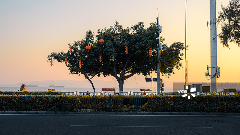厦门环岛路白城海滩夕阳海滨黄昏｜新年灯笼阵列与通信杆的暮色共生图片素材
