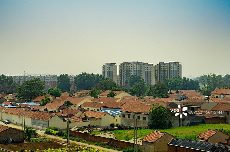 城市化进程中近处的房屋与不远处的高楼图片素材