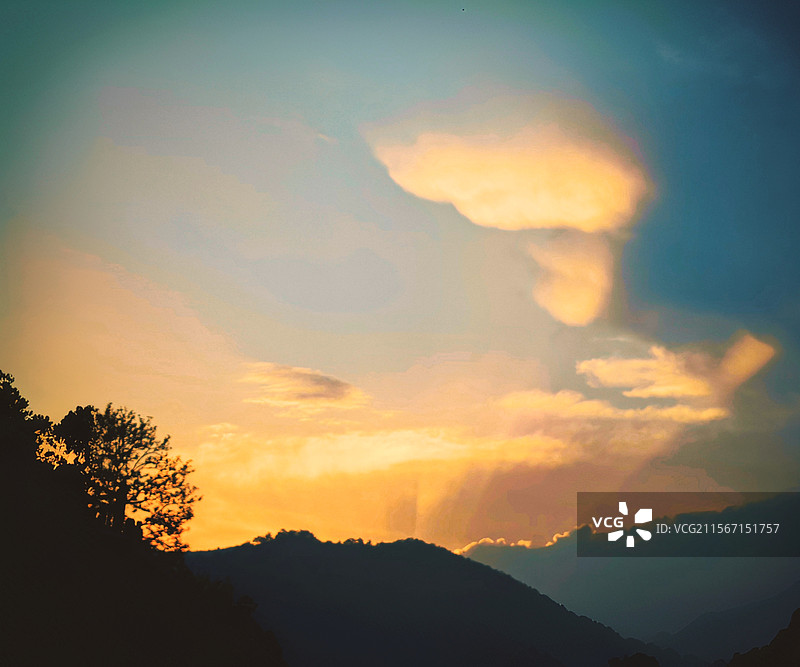 日出东方：太阳从山那边升起，染红了东边夭空，还有一点丁达尔光。图片素材