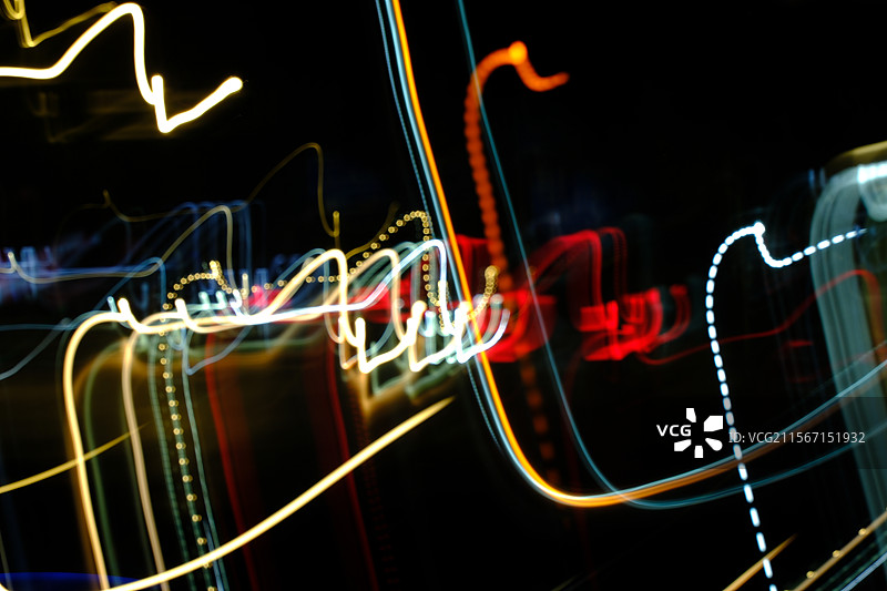 黑色夜幕背景下，艳丽的多彩光带。高清背景图。极简抽象。夜晚车流图片素材