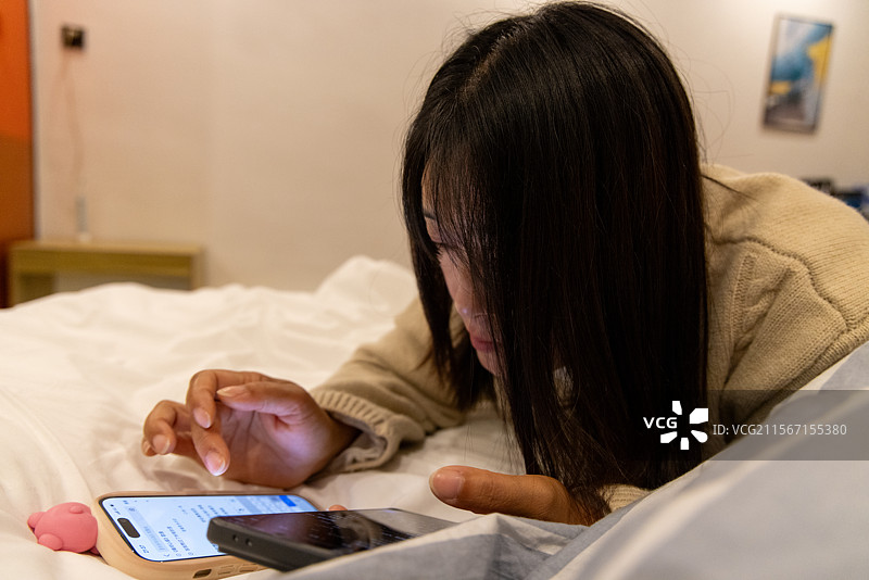 生活人像 美女趴在酒店床上玩手机刷视频图片素材