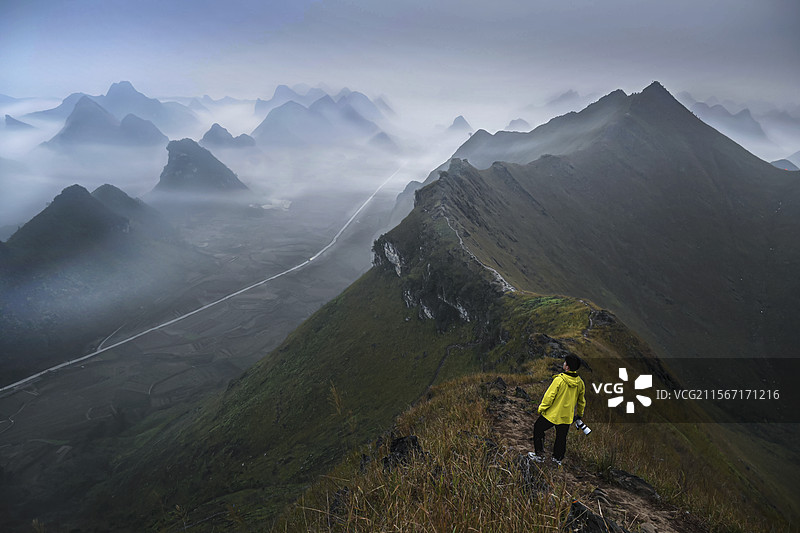背靠天空站在山上的人的后视图图片素材