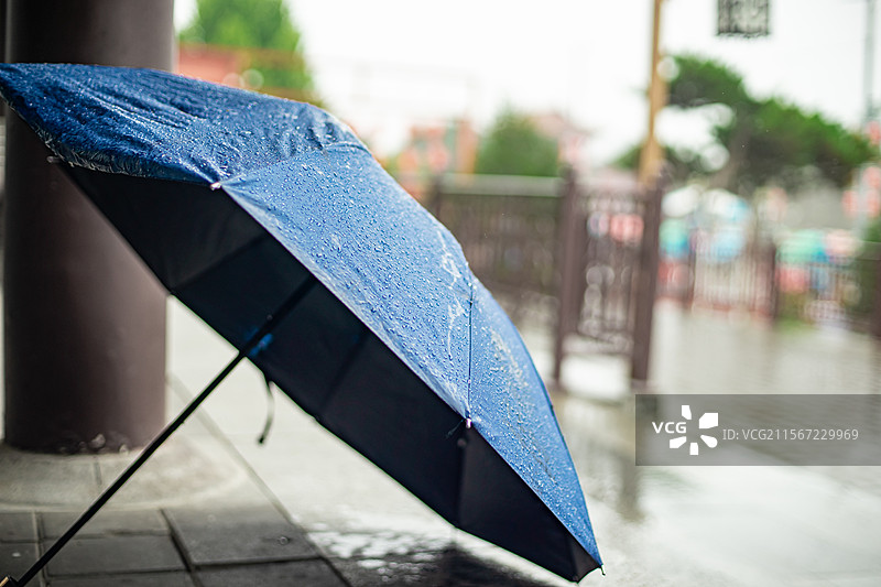 中国雨具拍摄主题，蓝色的雨伞防水布料上铺满了湿漉漉的透明的水珠雨水，户外白昼无人图像摄影图片素材