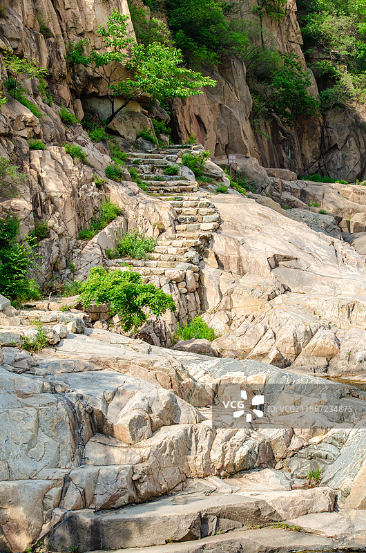 中国自然风光拍摄主题，山东省泰安市岱岳区彩石溪风景区，绿色的山脉悬崖峭壁和石头台阶楼梯，户外白昼无人图片素材
