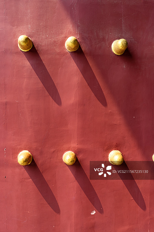 中国古代建筑城门大门拍摄主题。红色木质大门和成一排的黄的门钉，户外白昼无人图像静物摄影图片素材