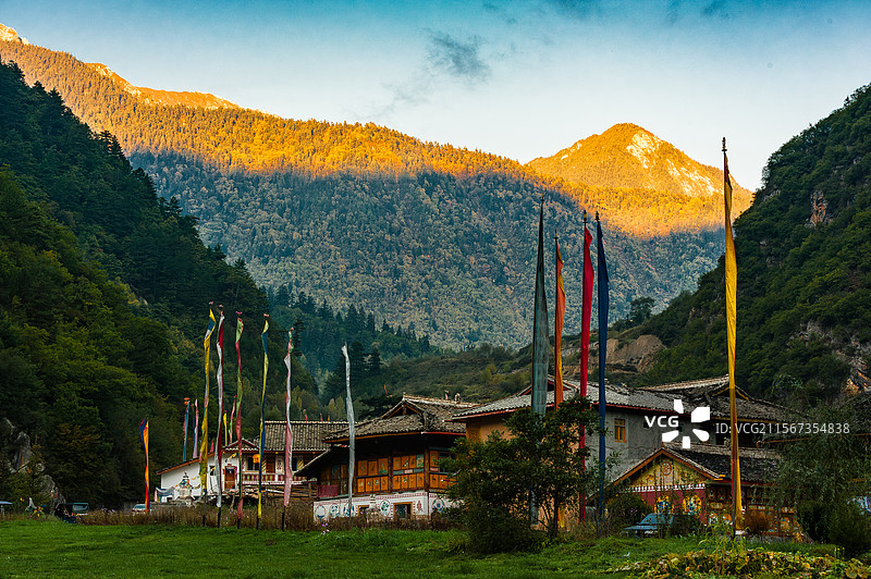 中国四川省九寨沟，插着经幡的藏族村寨和日照金山图片素材