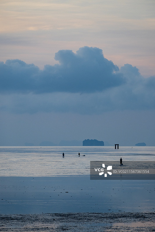 普吉岛海边公园的日出，当地居民正在赶海图片素材