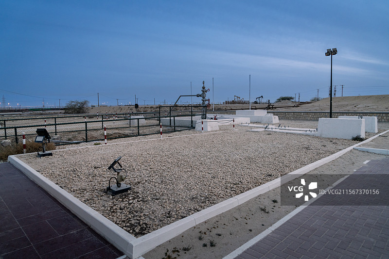 巴林和中东地区第一口油井，远处是坐落在杜汉山（海拔134米，巴林最高峰）上的正在工作的油井图片素材