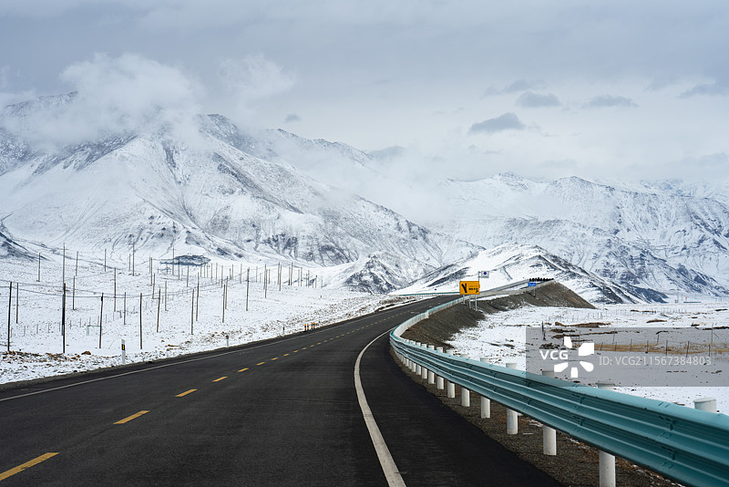 被大雪覆盖的山脉和前进的公路图片素材