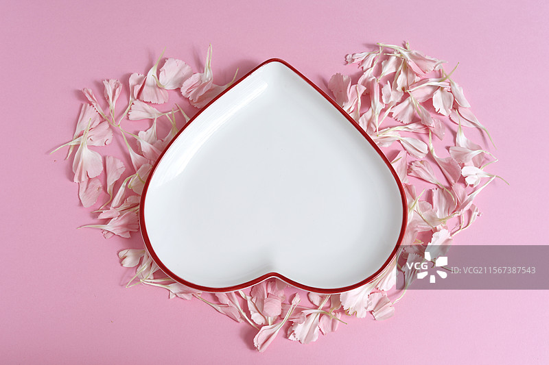 粉色背景上的情人节粉色花瓣和空白的空盘子背景图图片素材