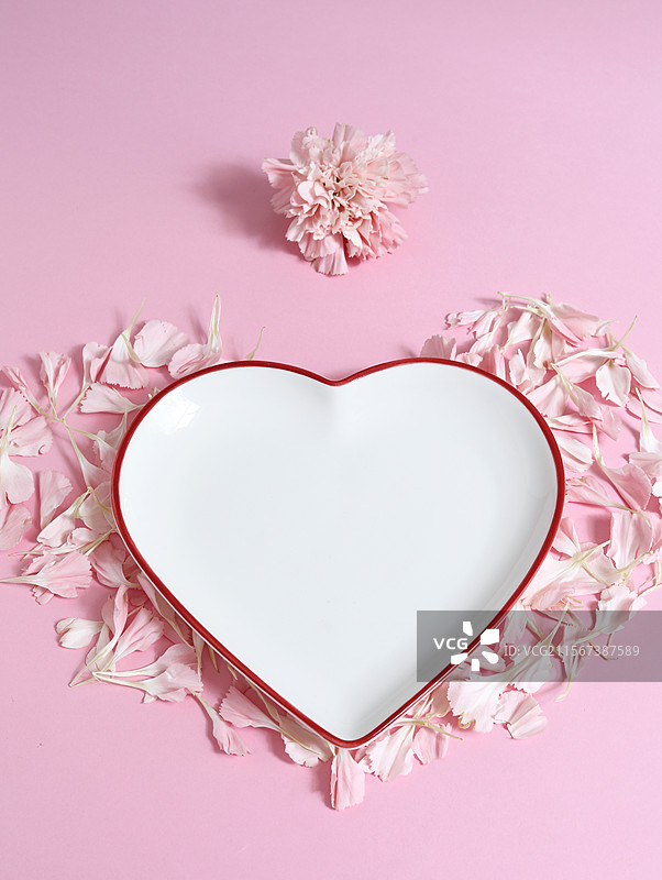 粉色背景上的情人节粉色花瓣和空白的空盘子背景图图片素材