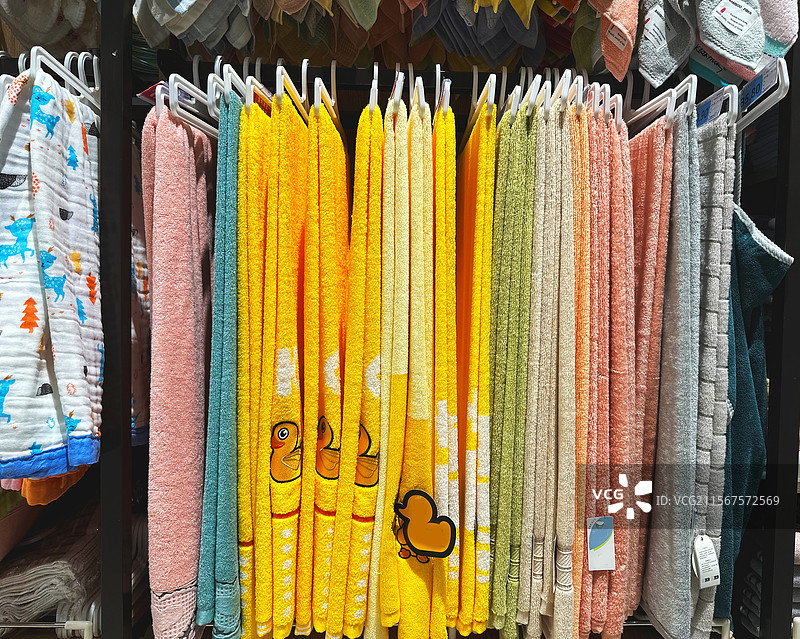 超市店铺店内货架上零售出售的彩色织物纺织品五颜六色毛巾全画幅背景图片素材