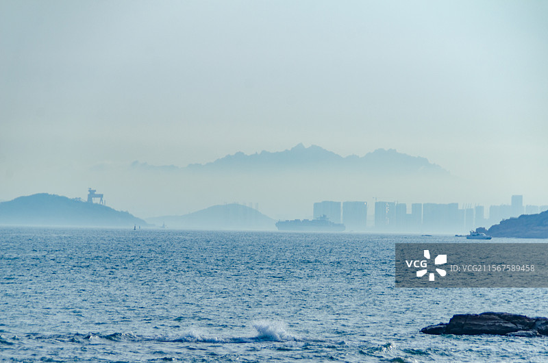 青岛燕儿岛远望云雾弥漫的山峰和高楼图片素材