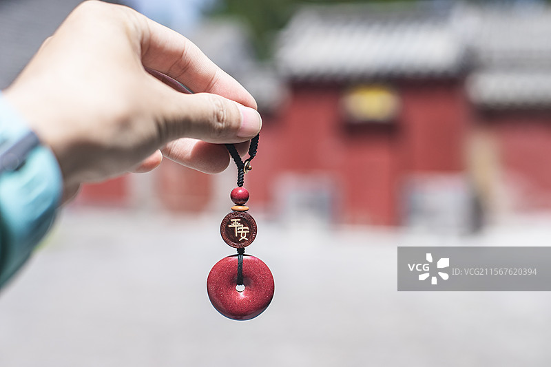 中国碧玉文化拍摄主题，手拎着拿着拖着着传统朱砂平安扣佩饰项坠艺术品工艺品，户外白昼无人图像摄影图片素材